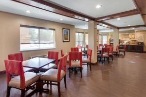 达拉斯北达拉斯康福特茵套房酒店的餐厅内带红色椅子和桌子的用餐室