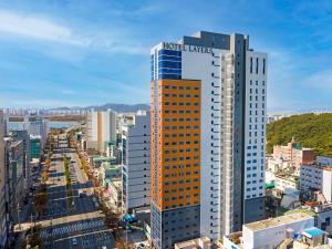 釜山Layers Hotel Busan Hadan的上面有活塞租赁标志的高楼