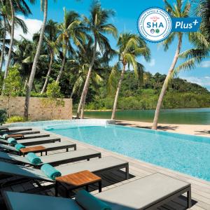 塔林甘海滩Avani Plus Samui Resort的一个带躺椅的游泳池,棕榈树
