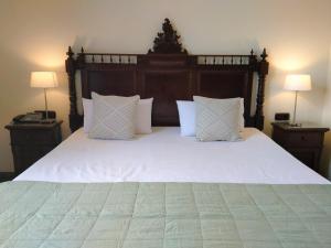 拉奥罗塔瓦维多利亚乡村酒店的卧室配有一张带白色床单和枕头的大床。