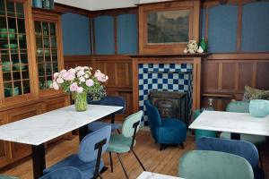 尼乌波特Blauwe Huis B&B的一间带桌椅和壁炉的用餐室