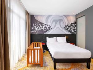 伊斯坦布尔ibis Styles Istanbul Merter的卧室配有一张床,墙上挂有绘画作品