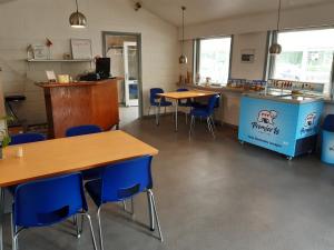 乌尔夫堡Rejkjær Camping Hytter & Lejligheder的配有桌子和蓝色椅子的教室和柜台