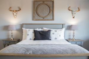 VryburgGame View Lodge的一间卧室配有一张带2个床头柜和2盏灯的床。