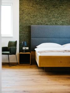 RechnitzWeingut Straka的一间卧室配有一张床和一把椅子