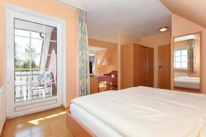 贝塞尔Hotel-Pension Störtebeker的一间卧室设有一张床和一个大窗户