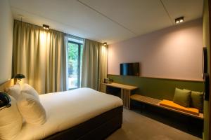阿姆斯特丹Hotel & Wellness Zuiver的酒店客房设有床和窗户。