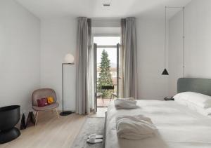 佛罗伦萨BB Hotels Aparthotel Collection Il Michelangelo的白色卧室配有一张大床和椅子