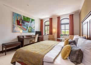 Marxen林登霍夫乡村旅馆的一间卧室配有一张大床和一张书桌