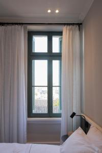 雅典Acron Athens的一间卧室设有一张床和一个大窗户