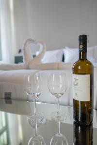 雅典Acron Athens的桌子上放有一瓶葡萄酒和两杯酒