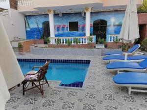 卢克索Luxor palace Apartments的一个带椅子的庭院和一个游泳池