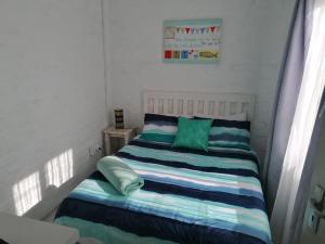阿尼斯顿Die Waenhuis的小卧室配有带绿色和蓝色枕头的床