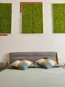 佛罗伦萨B&B Monteverdi L'Arancio的绿植物间的床和两个枕头