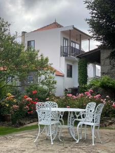 ParambosCasa do Beco B&B Douro - Guest House的房子前面的白色桌子和椅子