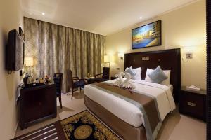 迪拜Smana Hotel Al Raffa的一间位于酒店客房内的带大床的卧室