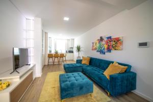 吉马良斯FERREIRA'S HOUSE Guimarães的客厅配有蓝色的沙发和电视