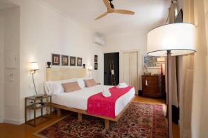 塞维利亚MDD4 Health Experience Hotel - Adults Only的卧室配有一张带红色毯子的白色床