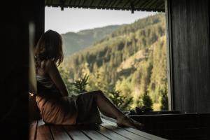 萨尔巴赫Goldstück - Adults Only的坐在窗台上,望着山的女人