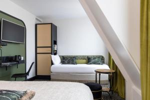 巴黎Grand Hotel Chicago的一间酒店客房,配有一张床和一台电视