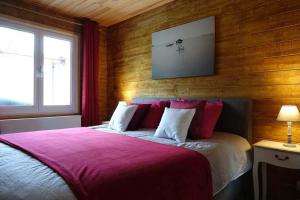 Hastière-par-delàLe Chalet de Hermeton的一间卧室配有一张带红色床单的大床