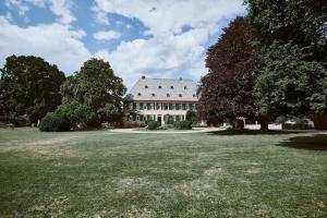 埃尔特维勒卡普豪森巴瑞尔酒店的一座大型白色房子,设有大草地庭院
