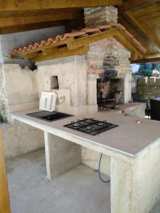 苏萨克Vila Flora的户外厨房配有炉灶和壁炉。