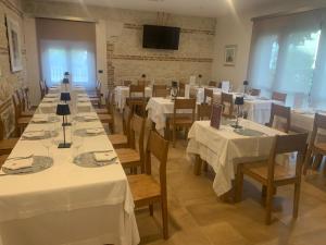 FrisaTenuta Micoli的一间配备有白色桌椅和电视的用餐室