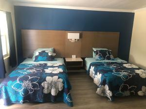 Salter PathSalter Path Inn的一间卧室设有两张带蓝色墙壁的床