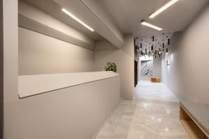 雅典Thisean Modern Suites By Athens Stay的走廊上设有白色墙壁和吊灯