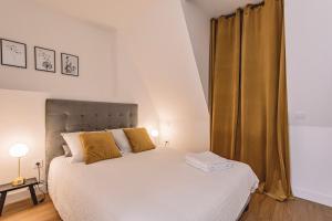 兰斯REIMS - Place du Forum - Cathédrale - Terrasse的卧室配有一张带黄色枕头的大型白色床。