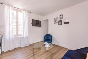 兰斯REIMS - Place du Forum - Cathédrale - Terrasse的客厅配有玻璃桌和蓝椅