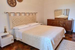 马戈马达斯La Terrazza sul Melograno - Magomadas的一间卧室配有一张床、梳妆台和镜子