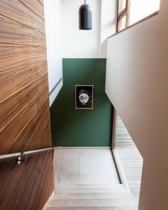 莫利纳塞卡No-Mad Green Hotel的走廊上设有绿色的墙壁和墙上的照片