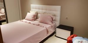 波尔蒂芒达罗沙公寓的卧室配有白色床和粉红色枕头