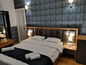 第比利斯3 Rooms Hotel的一间卧室配有一张大床和两张台灯。