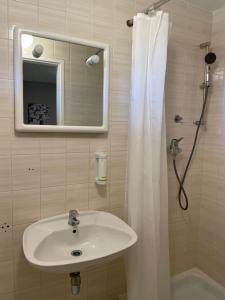 波尔托罗Villa Darina的浴室配有盥洗盆和带镜子的淋浴