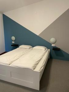 波尔托罗Villa Darina的卧室配有白色床和蓝色墙壁