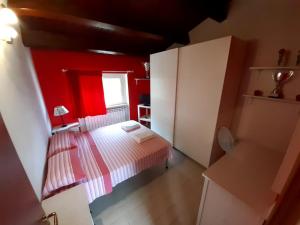 Torrevecchia TeatinaCasale Angela的一间小卧室,配有一张床和红色的墙壁
