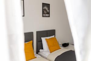 斯克拉斯卡波伦巴VILLA TO-TU的一张带橙色和白色枕头的床