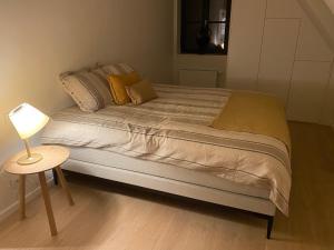 KnokkeLes Cigognes的卧室内的一张床位,配有桌子和灯