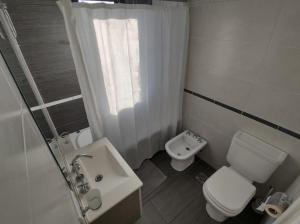 马德普拉塔Frente al mar charlone的白色的浴室设有卫生间和水槽。