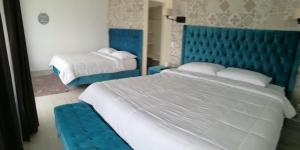 福尔图纳Hotel Arenal Vista Lodge的一间卧室设有两张床和蓝色床头板
