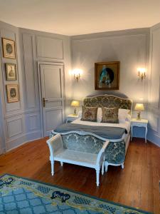 圣利斯Château Ratou的一间卧室配有一张床和一把椅子