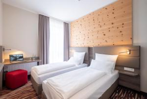 贝格基兴阿马罗酒店的酒店客房带两张床和一张红色凳子