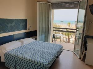 里米尼Hotel Giannini的一间卧室设有一张床和一个海景阳台
