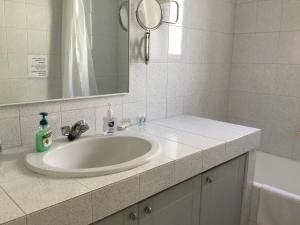 雅典AGIA PARASKEVI appartement près du métro的浴室设有白色水槽和镜子