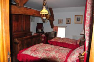 日安LES GUENINS的一间卧室配有两张床和吊灯。