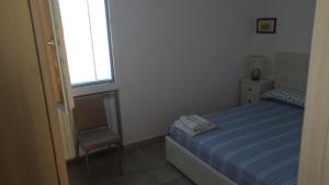 圣玛丽亚巴格诺Villa Aurora的一间小卧室,配有一张床和一把椅子