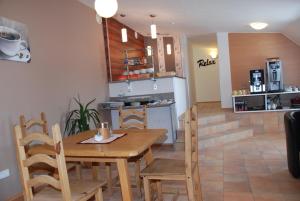 Wimpassing移动客房酒店的厨房以及带木桌和椅子的用餐室。